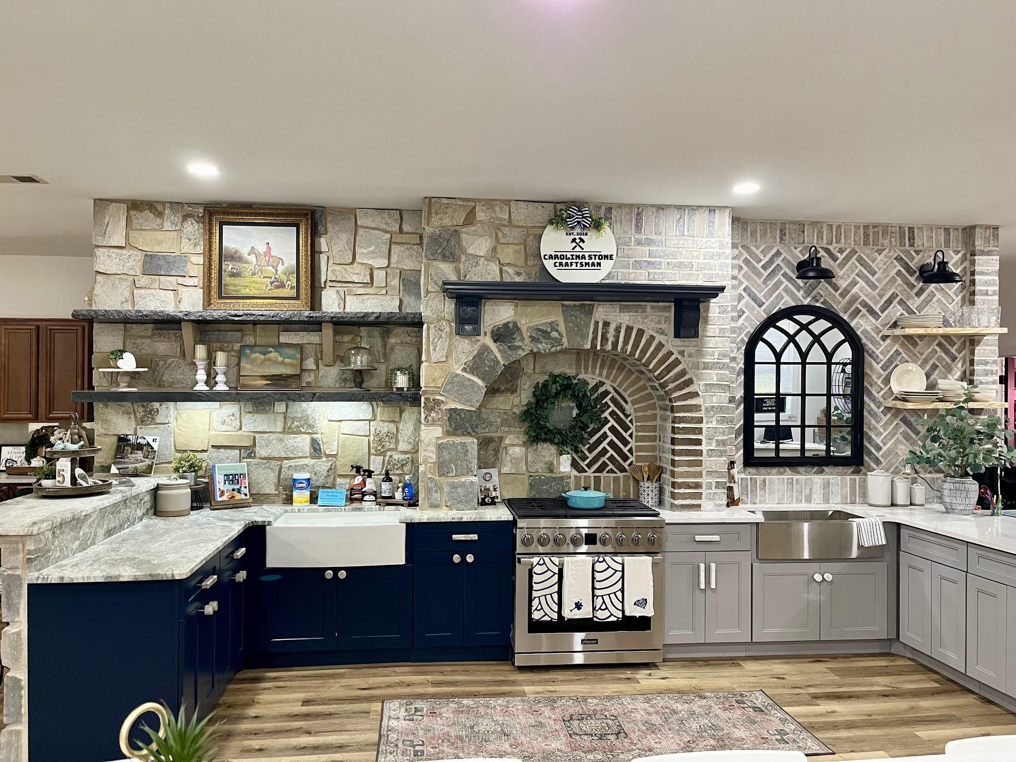 Showroom display kitchen with veined stone countertops, a stacked-stone wall and an arched brick alcove behind the range