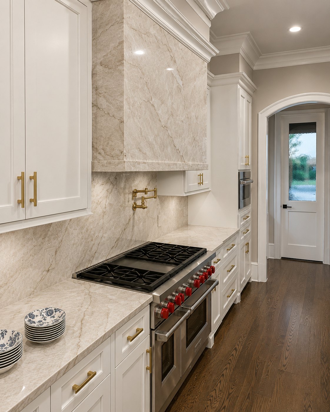 White kitchen with a red range and a marble splash