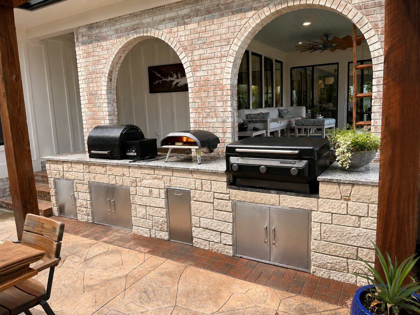 Outdoor kitchen with brick arches and twin grills over a stone base