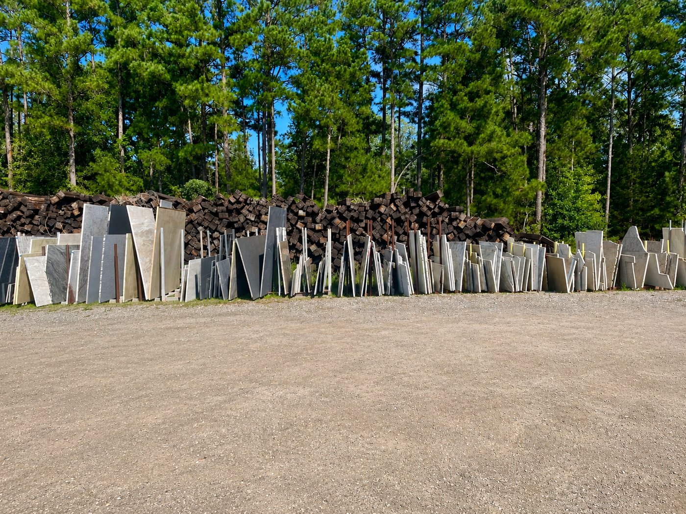 Full-size stone slabs racked upright in rows across the yard