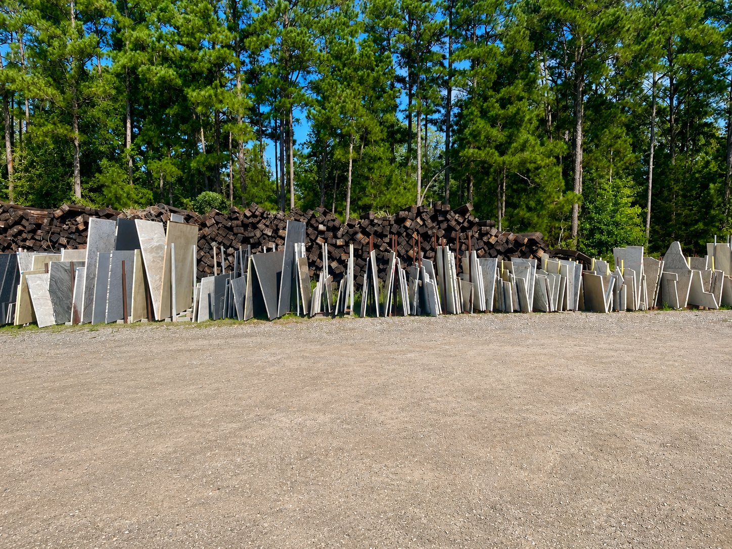 Full-size stone slabs racked upright in rows across the yard